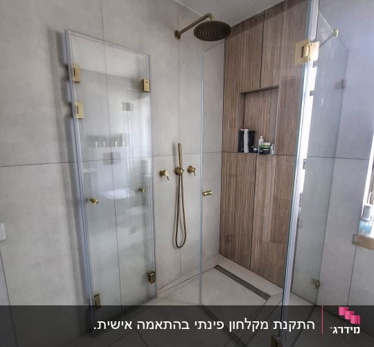 מקלחת עם דלתות זכוכית וברזי זהב